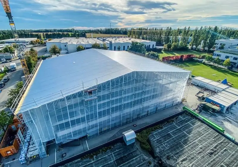 Komplett eingehauste Halle: Wetterschutzdach über der gesamten Dachfläche, seitlich mit Netzen verkleidet