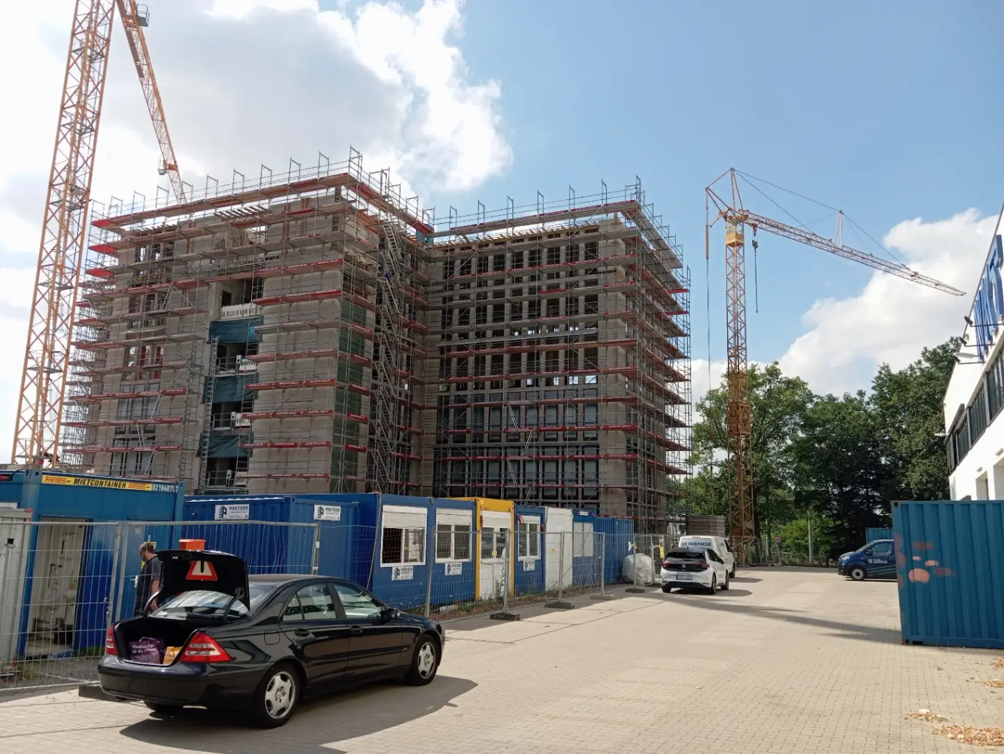 Baustelleneinrichtung neben dem eingerüsteten Bürogebäude