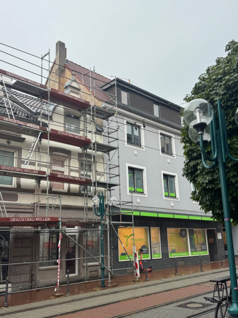 Fassadengerüst mit Fußgängerpassage in Bonn-Beuel, davor die Gleise der Straßenbahn