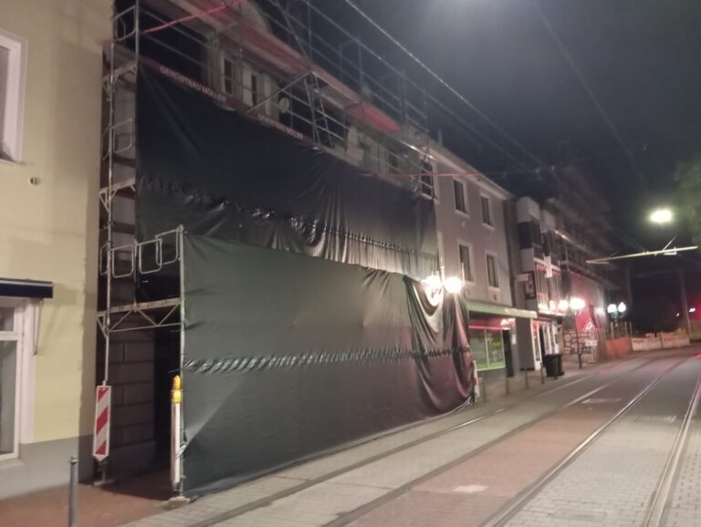 Mit EPDM-Kautschukfolie abgehängtes Fassadengerüst in Bonn-Beuel, aufgenommen in der Nacht der Montage