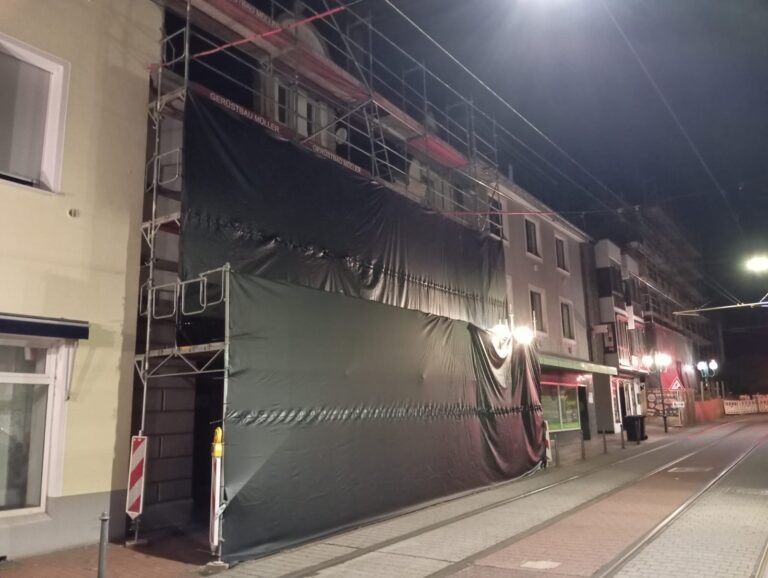 Fassadengerüst an der Straßenbahnstrecke in Bonn-Beuel, Straßenseite vollständig mit EPDM-Folie geschlossen