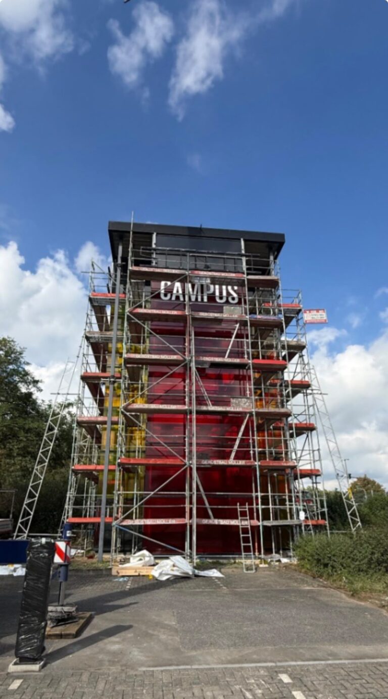 Freistehendes Gerüst rund um den gläsernen Turm an der Godorfer Hauptstraße in Köln-Godorf