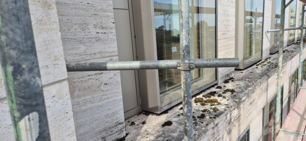 Verschmutzte Travertin-Fensterbank am AUREUM in Bonn vor der Fassadenreinigung